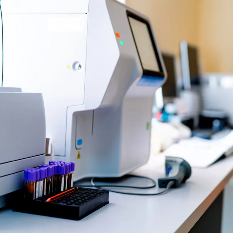 Un analizador de laboratorio con tubos de muestra sobre una mesa