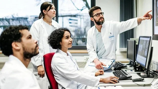Colegas de laboratório analisando resultados juntos em um computador
